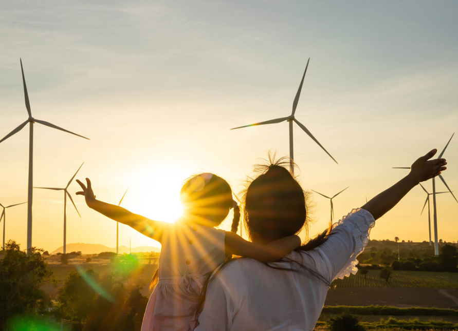 Imagen personas con parque eólico al fondo